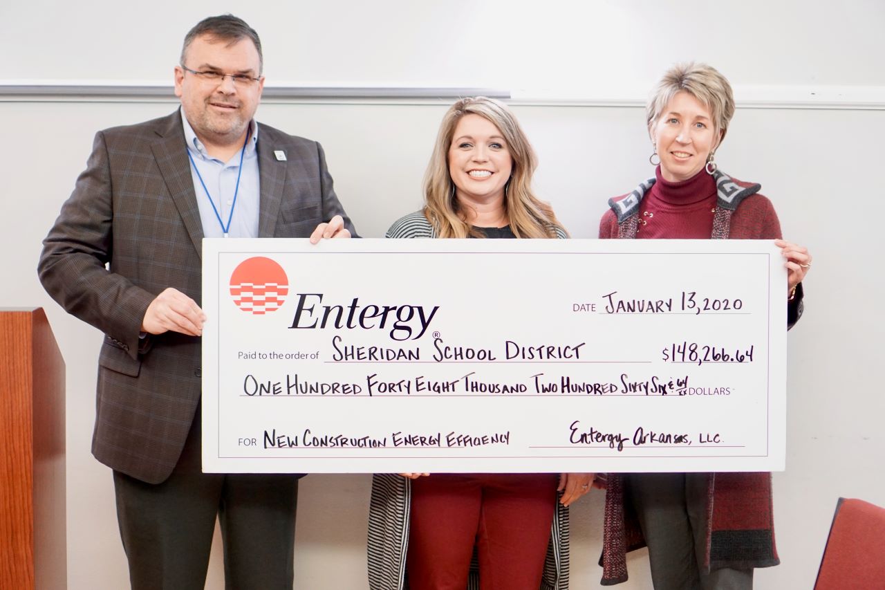 Jerrod Williams, superintendent of the Sheridan School District, Ashley Scott of CLEAResult and  Heather Szeflinski, CFO of the Sheridan School District, display the district's $148,266.64 incentives check from Entergy Arkansas.